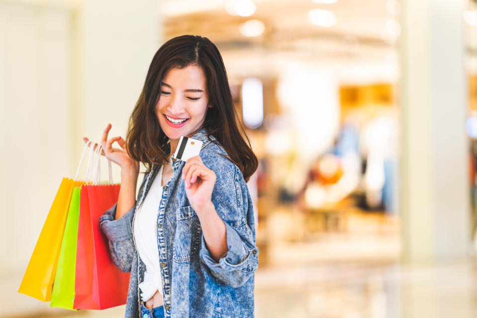 Woman happily wielding credit card while shopping