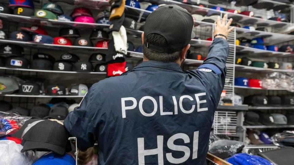 PHOTO: HSI Special Agent Nik counts possible counterfeit pro sports hats at a swap meet vendor in the outskirts of Las Vegas. (U.S. Immigration and Customs Enforcement)