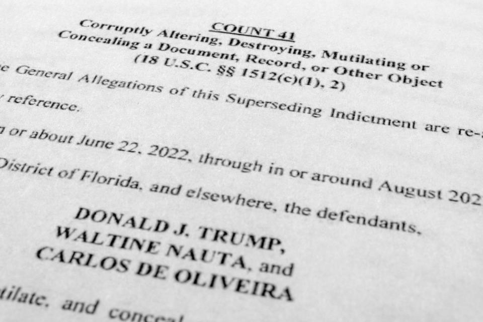 The updated indictment against former President Donald Trump, Walt Nauta and Carlos De Oliveira is photographed Thursday, July 27, 2023. Trump is facing accusations that he and aides asked a staffer to delete camera footage at his Florida estate in an effort to obstruct the classified documents investigations. The allegations were made Thursday in an updated grand jury indictment that adds new charges against Trump and adds another defendant to the case. (AP Photo/Jon Elswick)