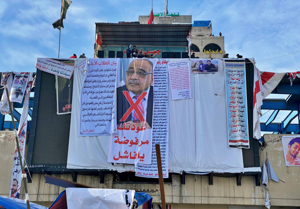 In this Monday, Jan. 13, 2020 photo, a poster with a defaced picture of Iraqi acting Prime Minister Adil Abdul-Mahdi, and Arabic that reads, "Your return is rejected, loser," hangs in Tahrir Square, in Baghdad, Iraq. Mass protests by young Iraqis against their country's ruling elite helped force the resignation of the prime minister, but with the focus now turning to the conflict between the United States and Iran, demonstrators fear the momentum is being drawn away from their goals. (AP Photo/Khalid Mohammed)