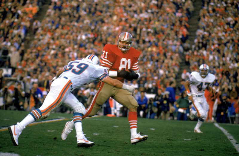 Russ Francis #81 of the San Francisco 49ers works to escape a tackle during Super Bowl XIX against the Miami Dolphins at Stanford Stadium, on January 20, 1985 in Stanford, California. The 49ers defeated the Dolphins 38 to16. (Photo by Tony Duffy/Getty Images)