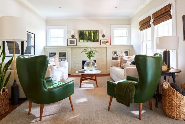 Hector Manuel Sanchez; Styling: Lydia Pursell The living room’s original windows and glass cabinets add historic charm, while green leather chairs offer a modern touch.