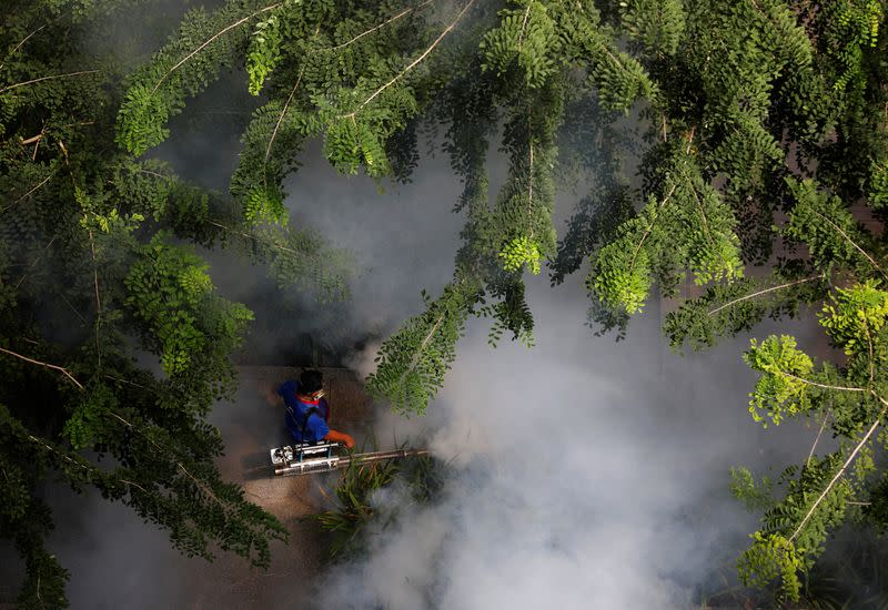 A worker fogs a housing estate for mosquitos in Singapore