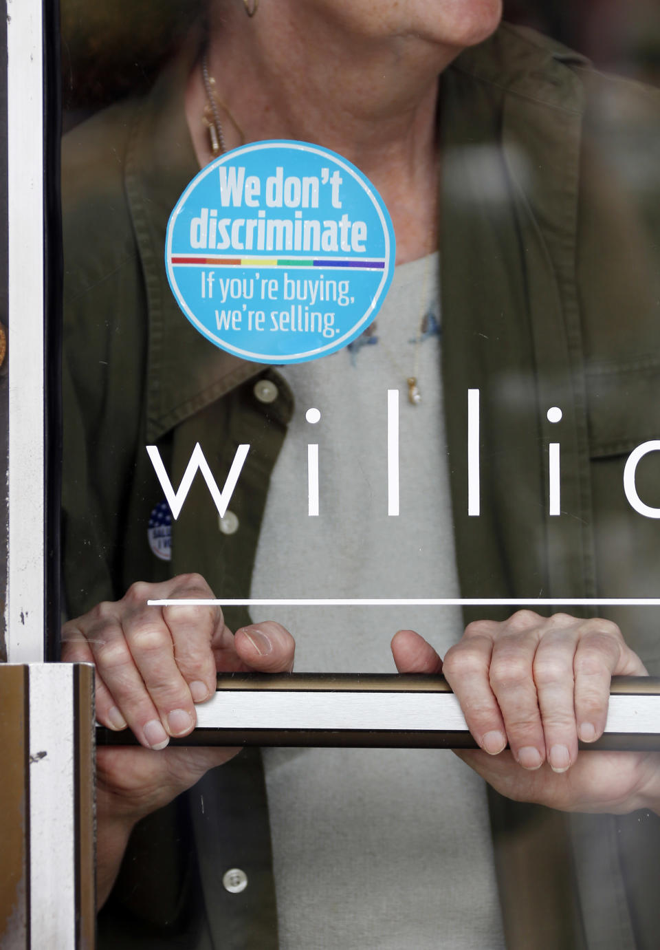 A Jackson hair salon displays a round, blue window sticker declaring: “We don’t discriminate. If you’re buying, we’re selling," Tuesday, April 22, 2014, in Jackson, Miss. The display stickers are the brain child of some Jackson business owners who display and have distributed them to other businesses as a show of support for gay and lesbian customers. The group sees this as an effort to push back against a religious-practices bill recently signed by Republican Gov. Phil Bryant. (AP Photo/Rogelio V. Solis)