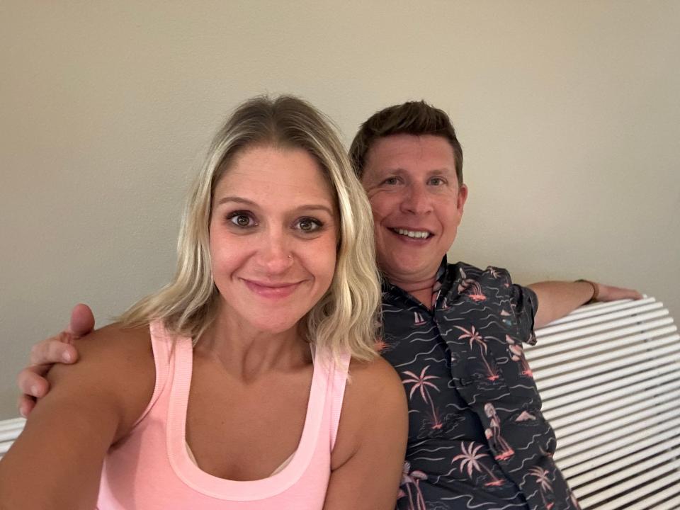 The author and her husband sitting on a lounge chair. Terri is wearing a pink tank top and her husband is wearing a printed button-up. 