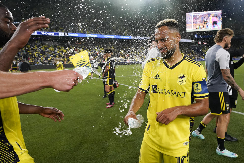 Los jugadores del Nashville SC lanzan agua a su compañero Hany Mukhtar tras la victoria 3-1 ante Columbus en la MLS, el domingo 28 de mayo de 2023, en Nashville. (AP Foto/George Walker IV)