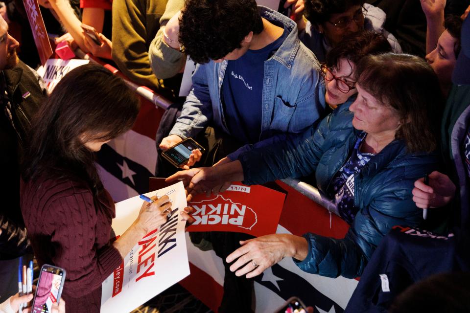 Republican US presidential candidate Nikki Haley (L) autographs a campaign placard during a campaign stop in Needham, Massachusetts, USA, 02 March 2024 (EPA)