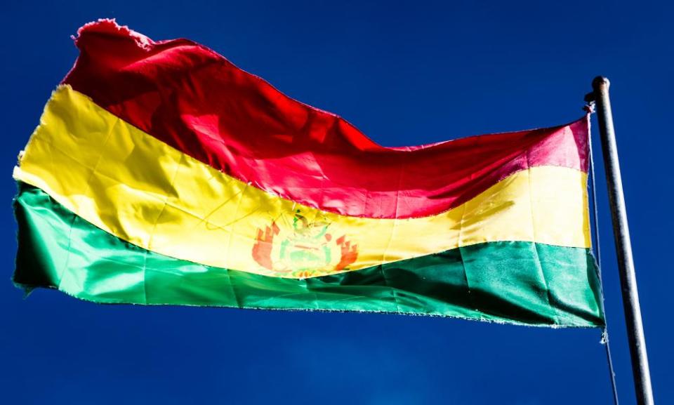 Bolivian flag flying in the wind against blue sky