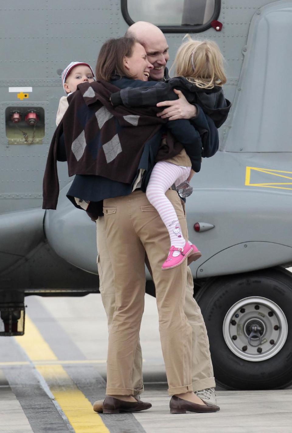 Released French hostage Nicolas Henin hugs his wife and children upon his arrival at the Villacoublay military airbase, outside Paris, Sunday April 20, 2014. Henin and three other French journalists kidnapped and held for 10 months in Syria returned home on Sunday to joyful families awaiting them. The four were freed by their captives a day earlier at the Turkish border. (AP Photo/Jacques Brinon)