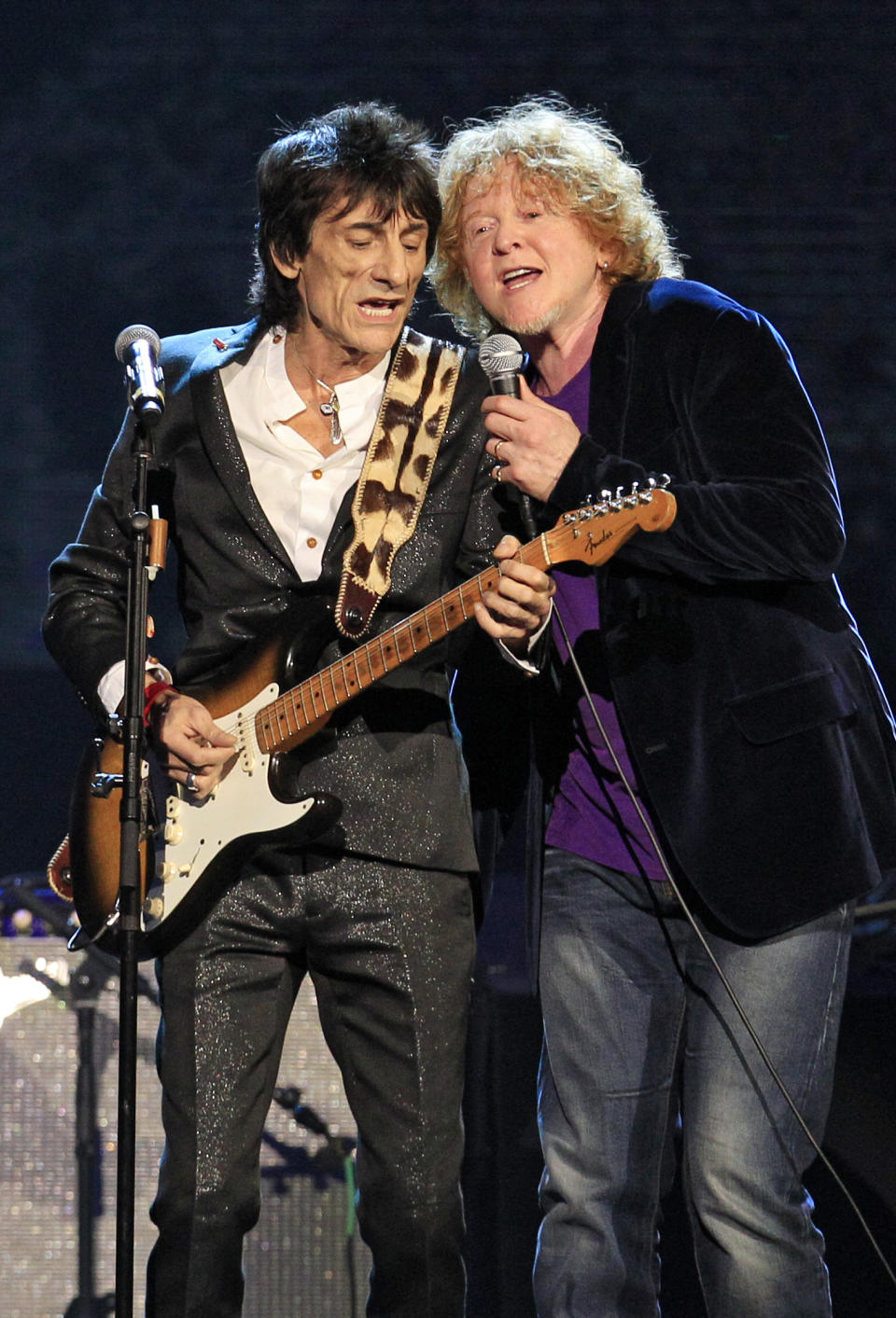 Ron Wood, left, performs with Simply Red lead singer Mick Hucknall after The Small Faces/Faces were inducted into the Rock and Roll Hall of Fame Saturday, April 14, 2012, in Cleveland. Hucknall subbed for Faces member Rod Stewart who was ill. (AP Photo/Tony Dejak)