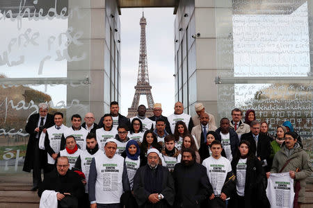 Front row, French author Marek Halter (4thR), Imams Hassen Chalghoumi (2ndL) and Mohamed Kamal Mostafa (C), gather at The Wall For Peace (Le Mur Pour La Paix) near the Eiffel Tower in Paris, France November 13, 2017 as part of ceremonies held for the victims of the 2015 Paris attacks which targeted the Bataclan concert hall as well as a series of bars and killed 130 people. Shirts carry the message, 'Muslims against Terrorism". REUTERS/Gonzalo Fuentes