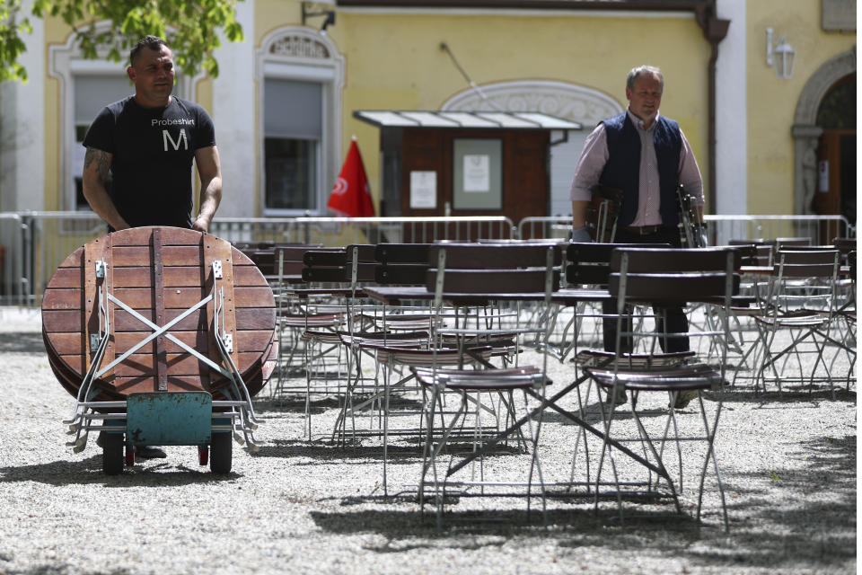 Employees of the 'Taxisgarten' beer garden prepare benches and tables for the re-opening in Munich, Germany, Monday, May 10, 2021. (AP Photo/Matthias Schrader)