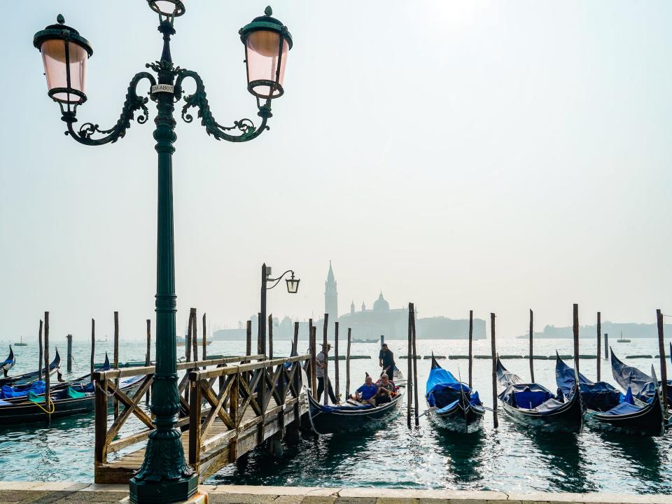 Gondolas line the water on the coast of Venice.