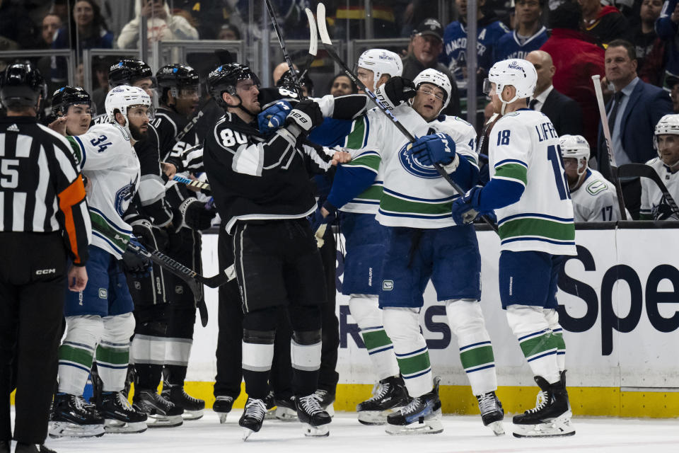 Los Angeles Kings center Pierre-Luc Dubois (80) gets into a fight with Vancouver Canucks defenseman Noah Juulsen (47) during the second period of an NHL hockey game Tuesday, March 5, 2024, in Los Angeles. (AP Photo/Kyusung Gong)