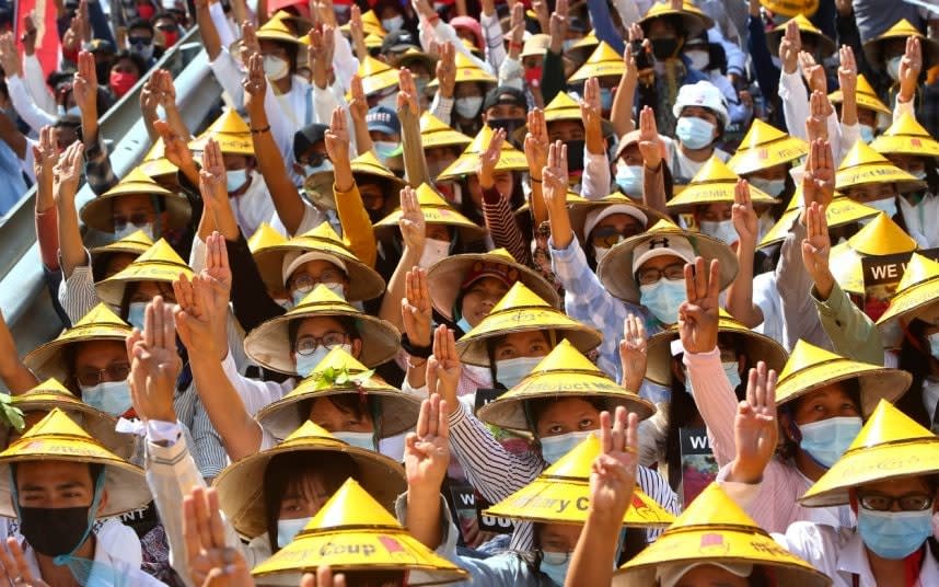 Anti-coup protesters in Myanmar hold up a three-fingered salute of defiance. CREDIT: AP - AP