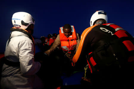 Rescuers of the Malta-based NGO Migrant Offshore Aid Station (MOAS) rescue migrants from a rubber dinghy in the central Mediterranean in international waters off the coast of Sabratha in Libya April 15, 2017. REUTERS/Darrin Zammit Lupi