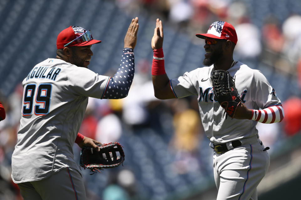 Miami Marlins' Bryan De La Cruz, right, and Jesus Aguilar (99) celebrate after a baseball game against the Washington Nationals, Monday, July 4, 2022, in Washington. The Marlins won 3-2 in ten innings. (AP Photo/Nick Wass)