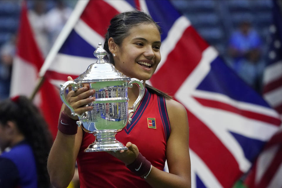FILE - Emma Raducanu, of Britain, holds up the U.S. Open championship trophy after defeating Leylah Fernandez, of Canada, during the women's singles final of the U.S. Open tennis championships on Sept. 11, 2021, in New York. Raducanu was 18 and ranked just 150th when she won last year's U.S. Open. Her title defense will begin Tuesday, Aug. 30, 2022, in a match against Alize Cornet, of France. (AP Photo/Elise Amendola, File)