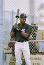 Michael Jordan swings a weighted bat while waiting for his turn in the batting cage during his first day of spring training with the Chicago White Sox, in Sarasota, Feb. 2, 1994. (AP Photo/John Swart)