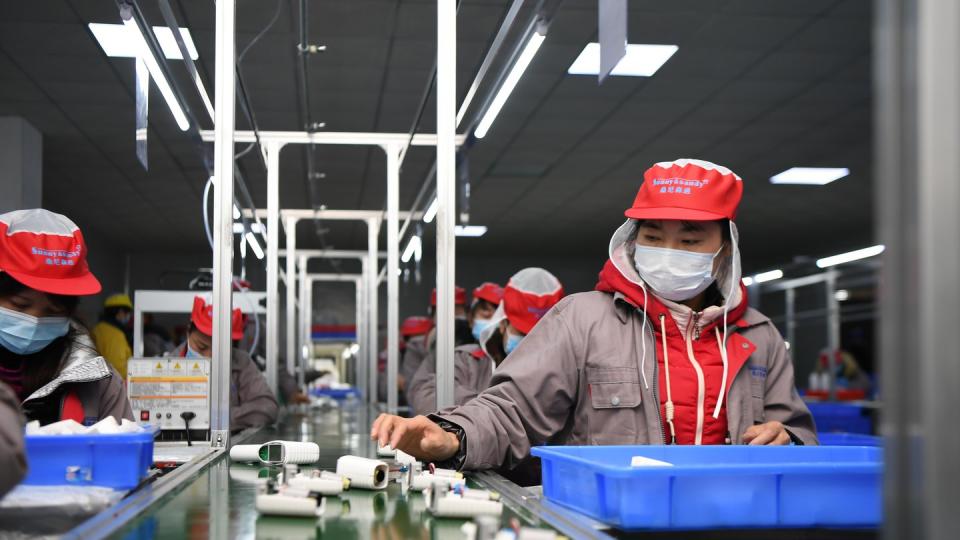 Menschen arbeiten in einer chinesischen Fabrik am Fließband. Seit Jahren verhandeln die EU und China über einen faireren Wettbewerb.