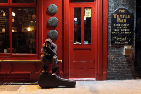 FILE PHOTO: A musician sits on a bench outside a pub in Temple Bar, Dublin, November 18, 2010. REUTERS/Cathal McNaughton/File Photo