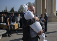 Timur Haligov, an Azerbaijani Turkish father embraces the body of his 10-month-old baby girl, Narin, who was killed by overnight shelling by Armenian forces. during a funeral ceremony, in Ganja, Azerbaijan, Saturday, Oct. 17, 2020. Azerbaijan has accused Armenia of striking its second-largest city with a ballistic missile that killed at least 13 civilians and wounded 50 others in a new escalation of their conflict over Nagorno-Karabakh. (Can Erok/DHA via AP)