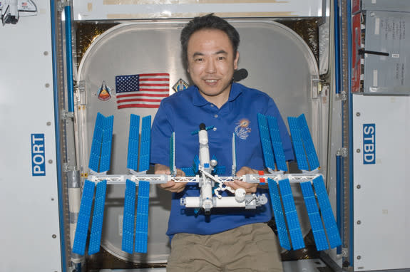 Japanese astronaut Satoshi Furukawa poses with the LEGO model of the International Space Station that he built on board the real space station.