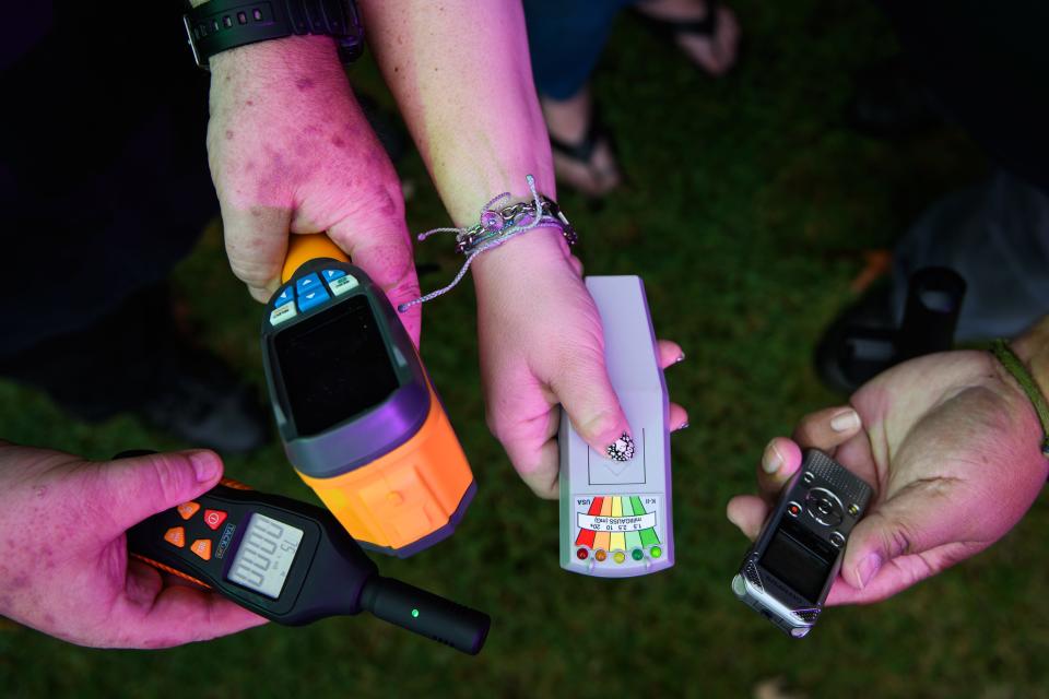 Tom Kuntz, left to right, Joanna Nunez and Armando Nunez hold out some of the gear they use during paranormal investigations. Pictured, from right to left, EMF meter, thermal imager, K-II EMF detector and a digital voice recorder.
