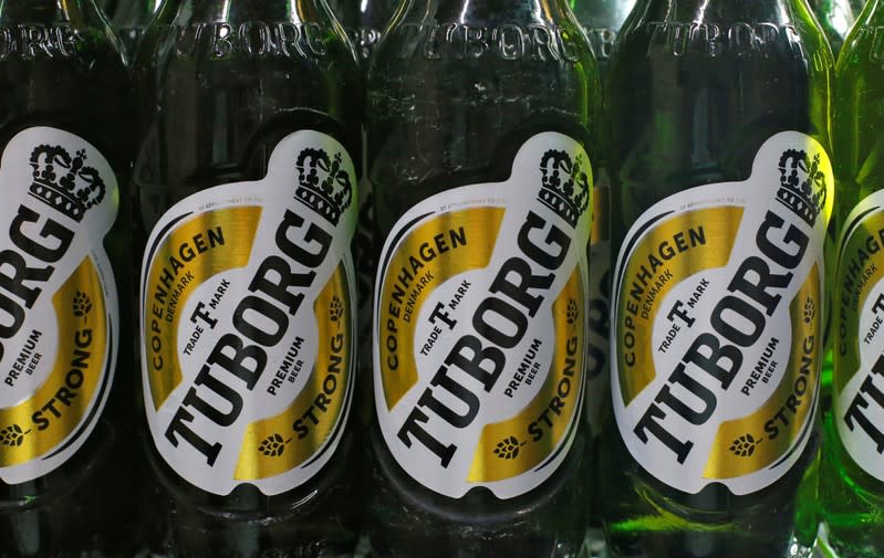 Tuborg beer bottles are seen in a cooler at a liquor shop in Kolkata