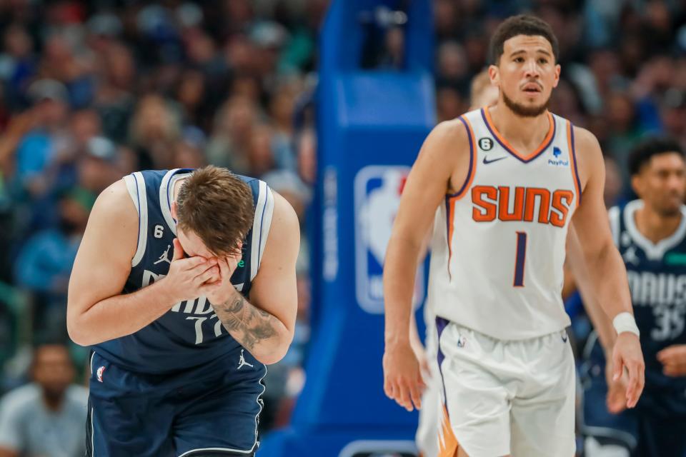 Dallas Mavericks guard Luka Doncic (77) reacts after a missed shot, as Phoenix Suns guard Devin Booker (1) looks on during the second half of an NBA basketball game, Sunday, March 5, 2023, in Dallas. (AP Photo/Gareth Patterson)