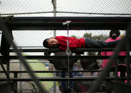 A migrant, part of a caravan of thousands from Central America trying to reach the United States, sleeps in a temporary shelter in Tijuana, Mexico, November 19, 2018. REUTERS/Hannah McKay