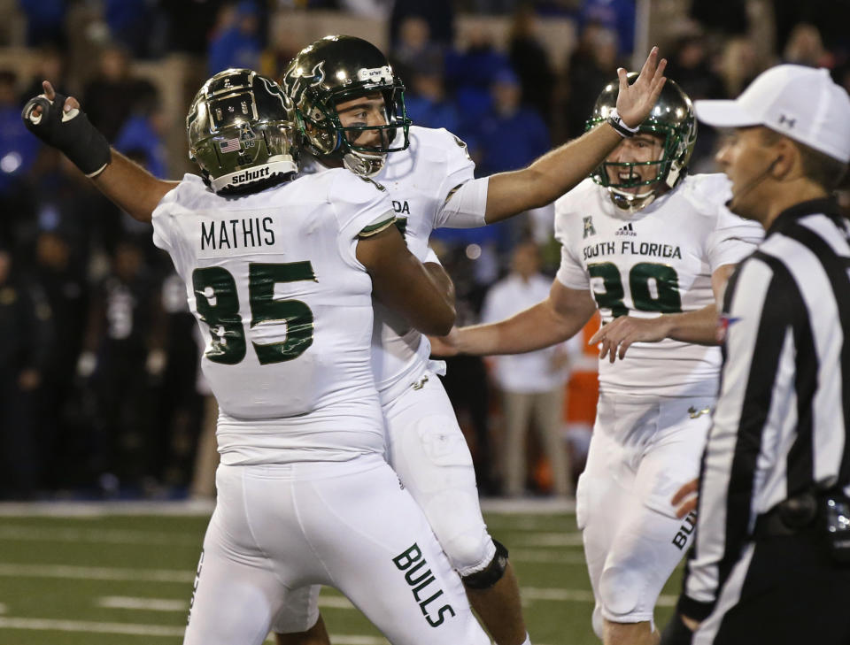 South Florida's Coby Weiss, center, celebrates with teammates Jacob Mathis (85) and Trent Schneider (39) after kicking the go-ahead field goal in an NCAA college football game against Tulsa in Tulsa, Okla., Friday, Oct. 12, 2018. (AP Photo/Sue Ogrocki)