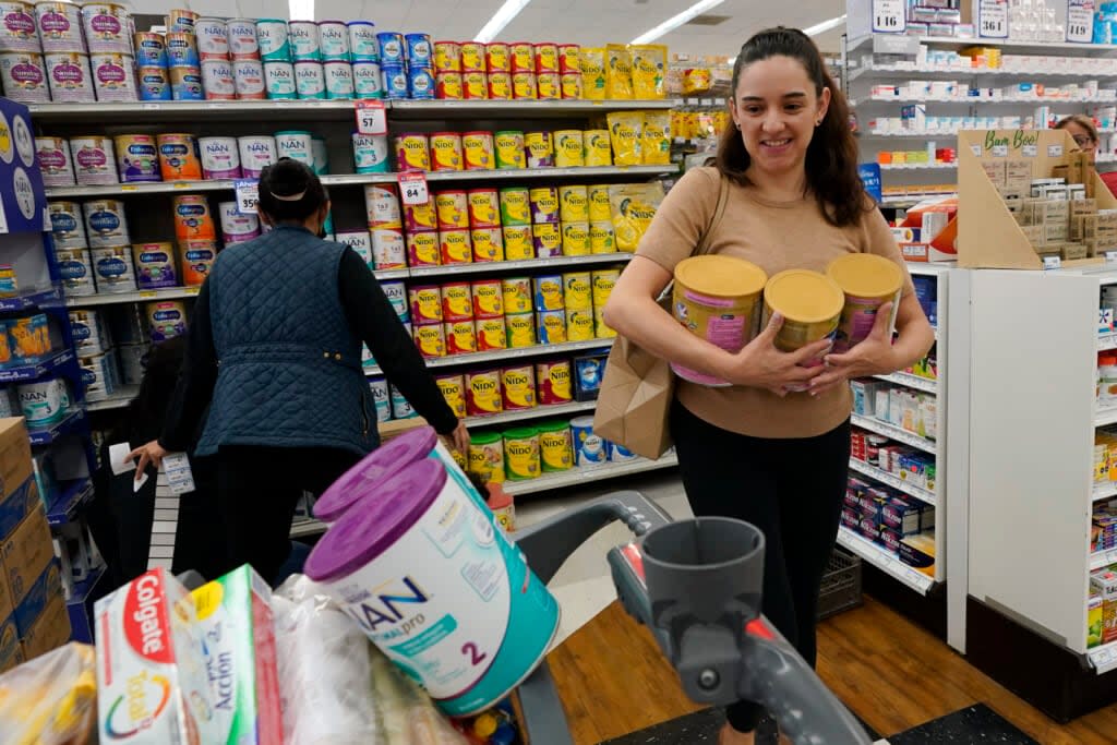 Michelle Saenz of Santee, Calif. buys baby formula at a grocery story across the border, Tuesday, May 24, 2022, in Tijuana, Mexico. As the baby formula shortage continues in the United States, some parents are opting to cross the border into Mexico, where the shelves are still stocked with options to feed their babies. (AP Photo/Gregory Bull)