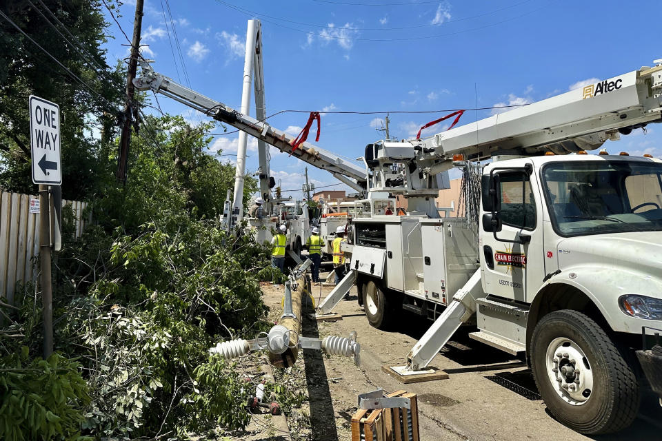 Crews replace utility poles along Durham Drive on Sunday, May 19, 2024, in Houston, Texas. Residents affected by deadly storms last week that left at least seven dead were finally getting some good news as officials said they expected power to be restored by Sunday evening to a majority of the hundreds of thousands still in the dark and without air conditioning amid hot and humid weather. (AP Photo/Mark Vancleave)