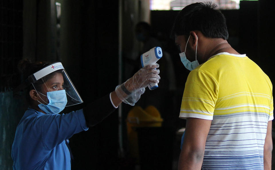 MUMBAI, INDIA - 2020/08/10: A health worker wearing a face shield is seen scanning the temperature of a suspected victim of coronavirus at Shivajinagar BMC school. 25 Covid-19 asymptomatic patients quarantined inside Shivajinagar (Brihanmumbai Municipal Corporation- BMC) school were screened and given medicines by healthcare workers. (Photo by Ashish Vaishnav/SOPA Images/LightRocket via Getty Images)