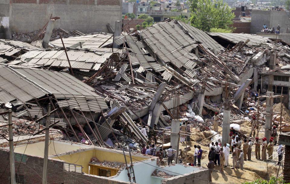 Rescue workers and Indian army soldiers search through the debris of a collapsed factory during a rescue operation in Jalandhar, India, Monday, April 16, 2012. Several people are feared to be trapped after a three-story building of a factory collapsed after a blast in the factory's boiler, according to local reports. (AP Photo/Altaf Qadri)