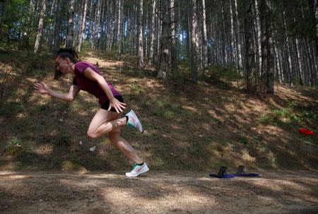 Kosovo's 400 metres runner Vijona Kryeziu runs in the woods of the village Rogane in Kamenica, Kosovo, July 30, 2016. Kryeziu trains in the woods because there was no athletics stadium nearby. The Rio Games will be the first to host athletes competing under the flag of Kosovo. REUTERS/Hazir Reka