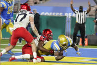 UCLA running back Brittain Brown, right, lunges into the end zone for a touchdown after a reception during the first half of an NCAA college football game against the Arizona onSaturday, Nov. 28, 2020, in Pasadena, Calif. (AP Photo/Marcio Jose Sanchez)