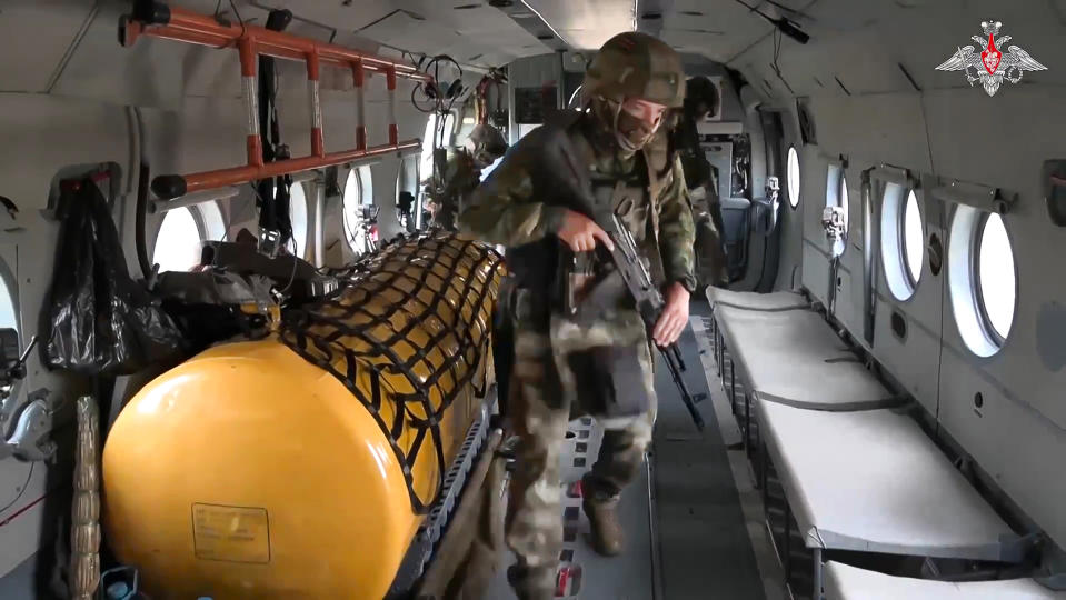 In this photo taken from video released by Russian Defense Ministry Press Service on Sunday, Sept. 24, 2023, soldiers take their places inside a military helicopter of the Russian air force prior to military action in an unknown location in Ukraine. (Russian Defense Ministry Press Service via AP)