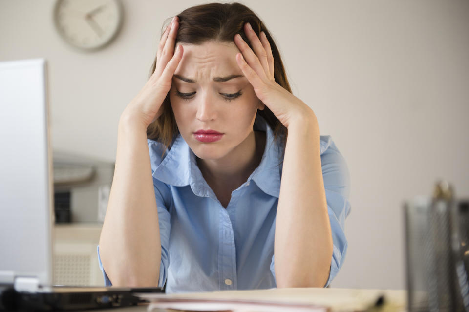 Businesswoman with her head in her hands looking frustrated