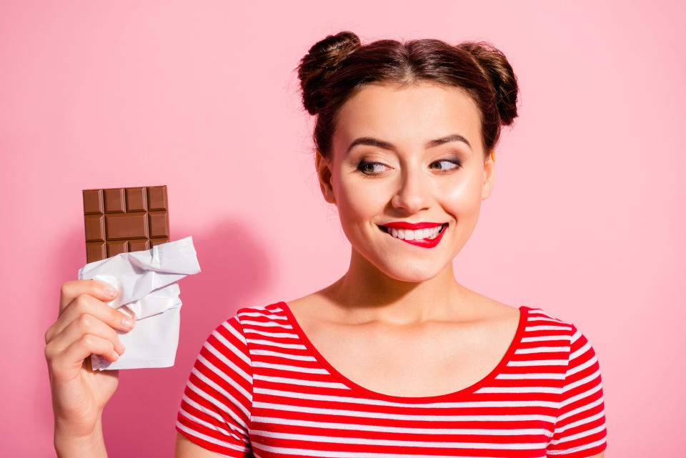Close-up portrait of nice cute charming attractive winsome glamorous cheerful girl wearing striped t-shirt holding in hands looking favorite dessert life lifestyle advert isolated on pink background.