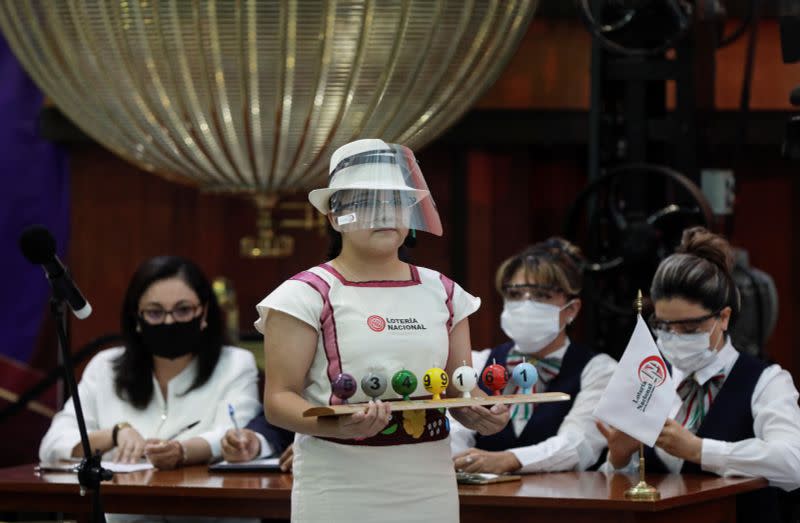 A girl holds lottery balls during a lottery raffle for the value of the last president's luxury plane at the National Lottery building in Mexico City