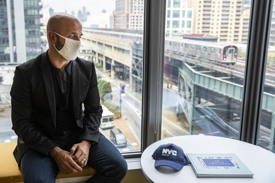 Dr. Demetre Daskalakis, New York City deputy health commissioner, speaks to a reporter on battling the coronavirus pandemic through contact tracing near the Queensboro Plaza commuter thoroughfare, Wednesday, Aug. 12, 2020, in New York. The city has hired more than 3,000 tracers and the city says it's now meeting its goal of reaching about 90% of all newly diagnosed people and completing interviews with 75%. (AP Photo/John Minchillo)