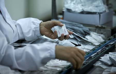 An employee holds condoms in a factory in Buenos Aires