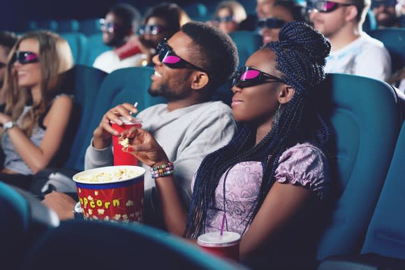 A couple watching a 3-D movie at a theater