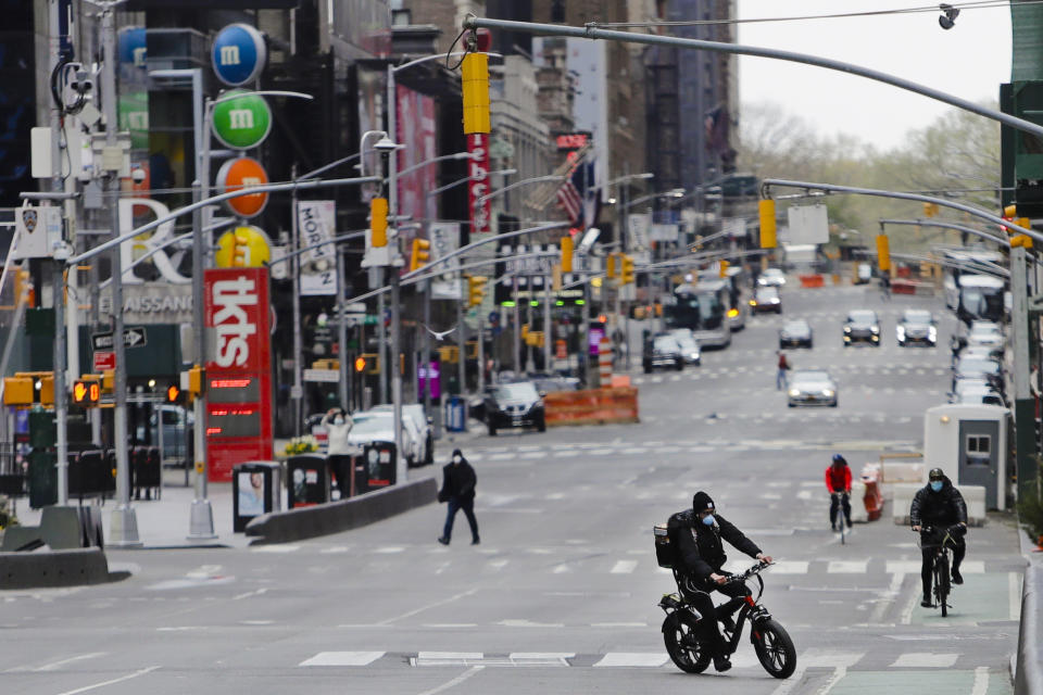 FILE - This April 17, 2020 file photo shows pedestrians and cyclists moving through an empty Times Square in New York. COVID-19 has shaken theater fans and shuttered all New York City's venues, including Broadway, which grossed $1.8 billion last season and attracted a record 15 million people. How Broadway — one the city's jewels — will reopen is still not clear. (AP Photo/Frank Franklin II, File)