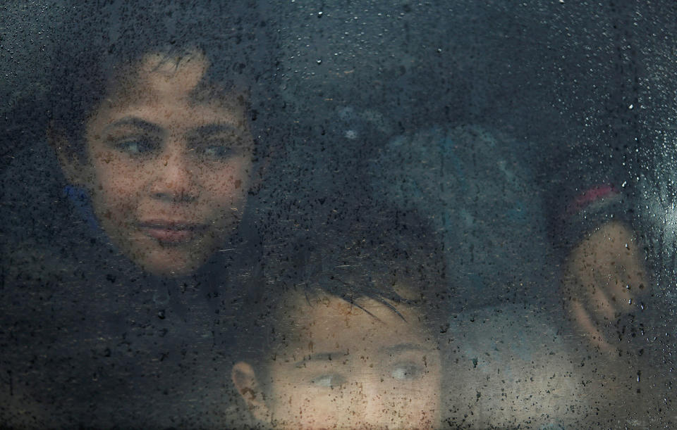 Displaced Iraqi children look out of a bus window