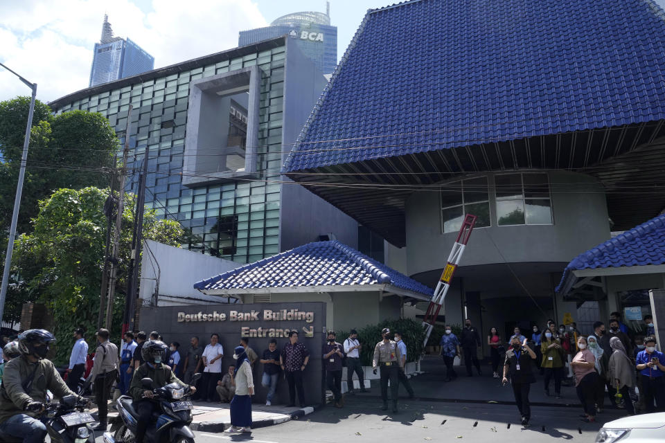 People wait outside an office building after being evacuated following an earthquake, Monday, Nov. 21, 2022, at the main business district in Jakarta, Indonesia. An earthquake shook Indonesia's main island of Java on Monday damaging dozens of buildings and sending residents into the capital's streets for safety. (AP Photo/Tatan Syuflana)