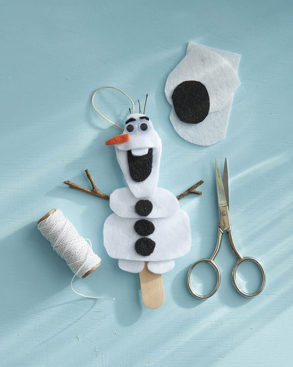 olaf ornament made of white and black felt, with scissors, felt and white string around it