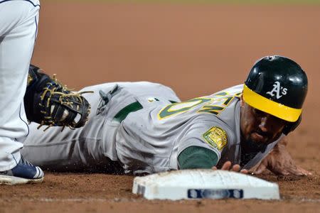 Jun 19, 2018; San Diego, CA, USA; Oakland Athletics shortstop Marcus Semien (10) dives back to first before the tag of San Diego Padres first baseman Eric Hosmer (left) at Petco Park. Mandatory Credit: Jake Roth-USA TODAY Sports